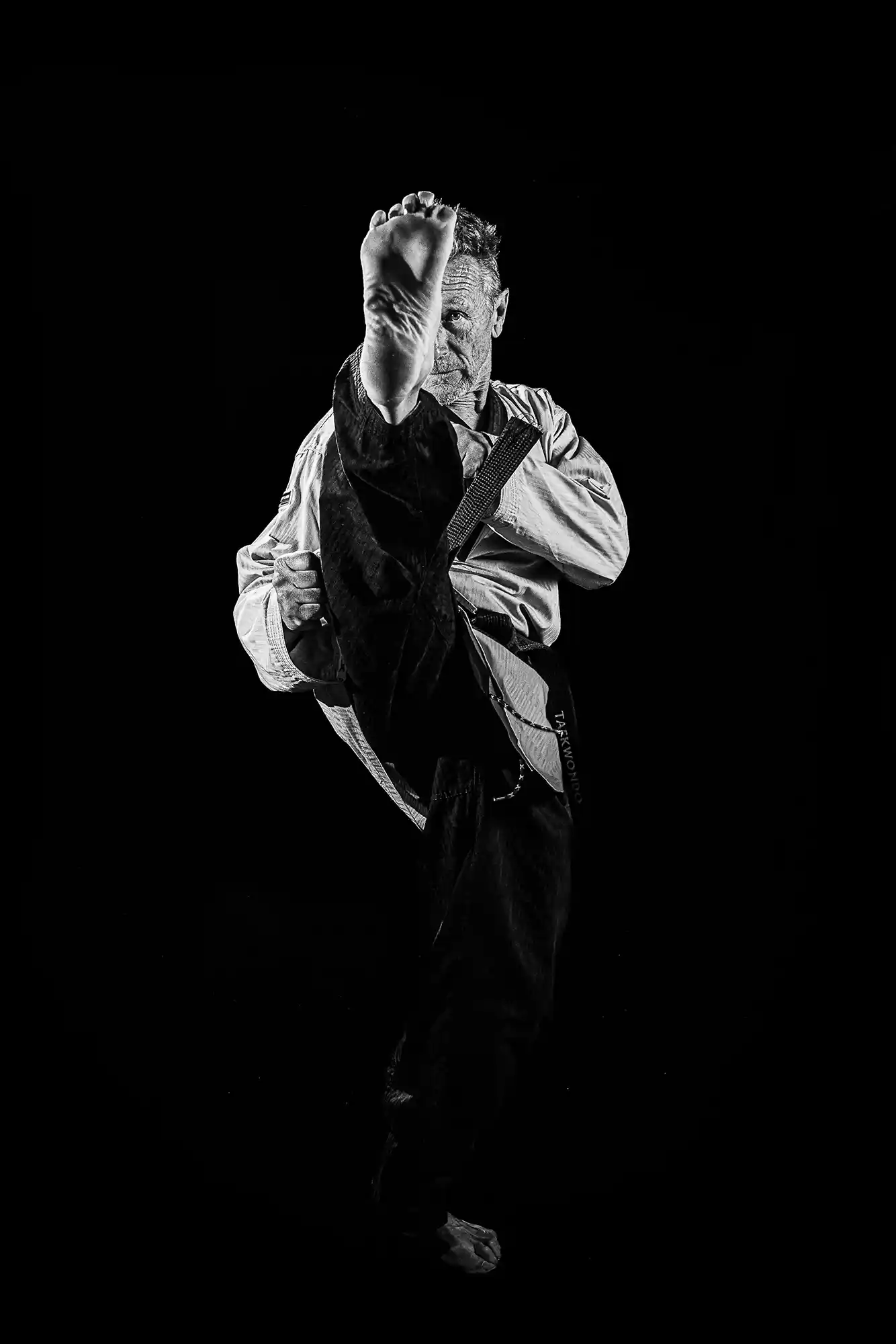 Portrait studio maître taekwondo kick frontal noir et blanc — Lawrence Banahan